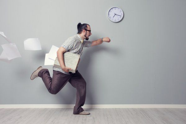 man running as he looks at his watch