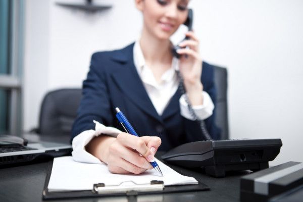 woman answering call and taking down notes